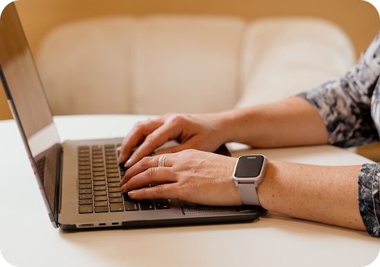 A person's hands on a macbook laptop typing